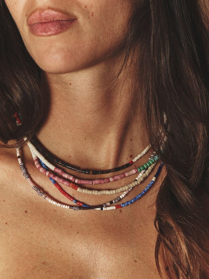 Layered multicolor handmade seed-bead necklaces worn close-up, created through The Beading Project.